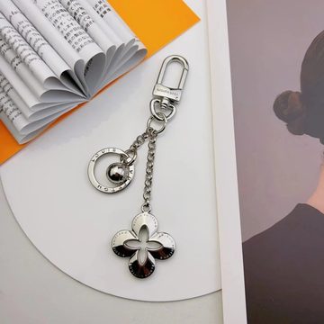 Silver key ring with a round charm and a black and silver flower charm
