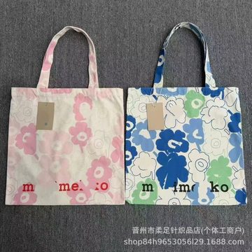 Two flat canvas tote bags with large flower prints, one pink and one blue