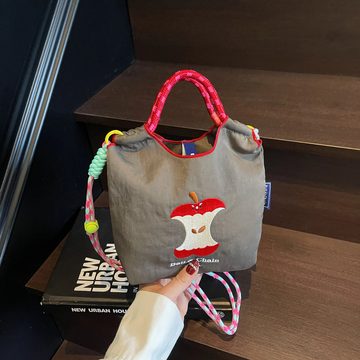 Grey drawstring bag with an embroidered apple core and a braided rope handle, held on stairs