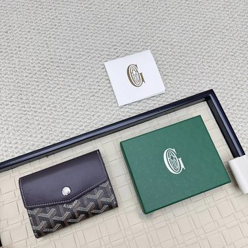 Small black flap coin purse with a printed lower panel next to a green box