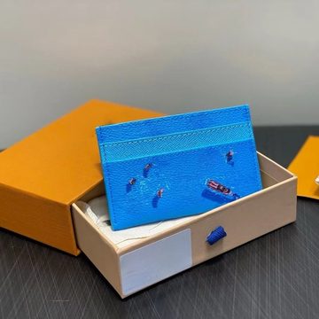 Bright blue card holder printed with small swimmers, resting in an open orange box